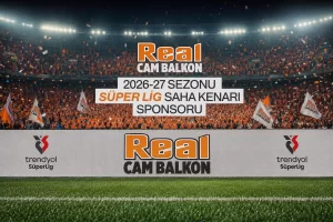 real-cam-balkon-2026-27-super-ligde Stadium filled with orange-clad fans; large banners read Real CAM BALKON and Turkish sponsor text promoting the 2026-27 season SÜPER LİG sponsor.